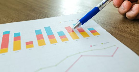 Analytics - Person Holding Pen Pointing at Graph