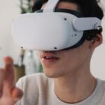 Virtual Reality And Augmented Reality - Young male interacting with virtual reality headset in apartment