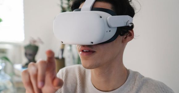 Virtual Reality And Augmented Reality - Young male interacting with virtual reality headset in apartment