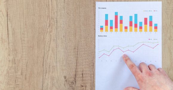 Analytics - Person Pointing Paper Line Graph