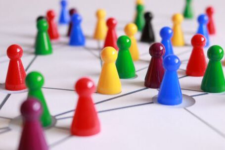 Teamwork - Close Up Photography of Yellow Green Red and Brown Plastic Cones on White Lined Surface