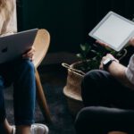 Home Gadgets - Photo of Couple Talking While Holding Laptop and Ipad