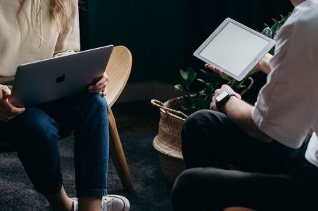 Home Gadgets - Photo of Couple Talking While Holding Laptop and Ipad