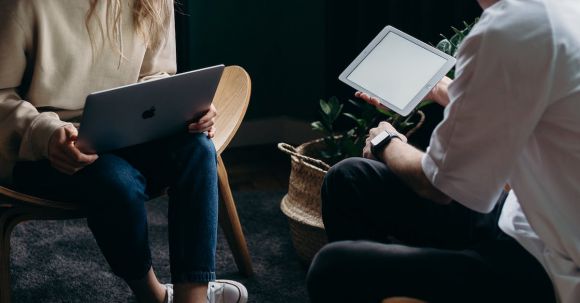 Home Gadgets - Photo of Couple Talking While Holding Laptop and Ipad