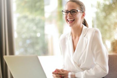 Career - Laughing businesswoman working in office with laptop