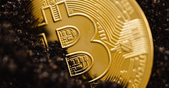 Blockchain Technologie - Close-Up Shot of a Bitcoin Buried in the Ground