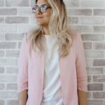 Career - Woman in Pink Cardigan and White Shirt Leaning on the Wall