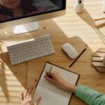 Video Conference - Person Writing on Notebook