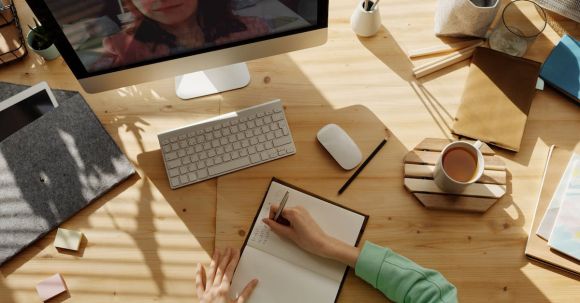 Video Conference - Person Writing on Notebook