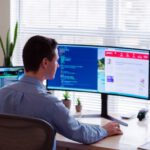 Software - man in gray dress shirt sitting on chair in front of computer monitor