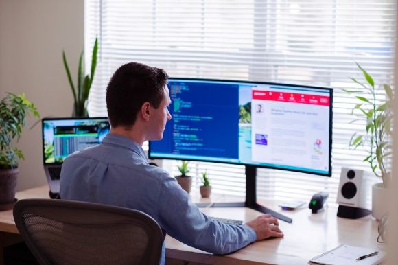 Software - man in gray dress shirt sitting on chair in front of computer monitor