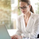 Career - Concentrated female entrepreneur typing on laptop in workplace