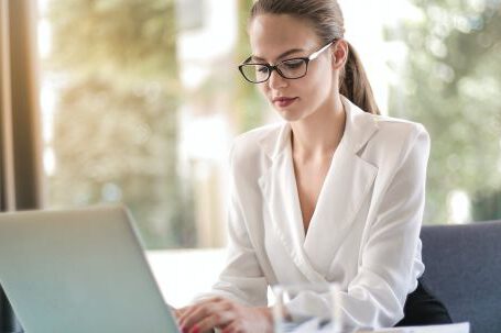 Career - Concentrated female entrepreneur typing on laptop in workplace