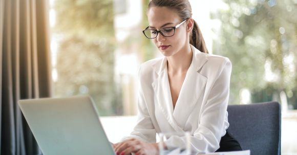 Career - Concentrated female entrepreneur typing on laptop in workplace