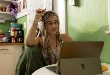 Laptop - a woman with dreadlocks sitting in front of a laptop computer