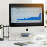 Technology - Silver Imac Displaying Line Graph Placed on Desk