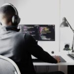 Debugging - man in black long sleeve shirt wearing black headphones sitting on chair