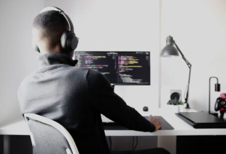 Debugging - man in black long sleeve shirt wearing black headphones sitting on chair