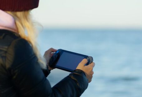 Pc - a woman holding a game controller in front of a body of water